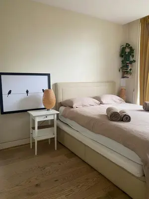 a bedroom with a bed and a table with a tv at Spacious Room with private king bathroom in Amsterdam