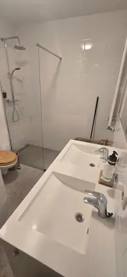 a white bathroom with a sink and a shower at Spacious Room with private king bathroom in Amsterdam