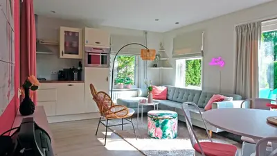 a living room with a couch and a table at Delightful tropical retreat close to the sea in Warmenhuizen