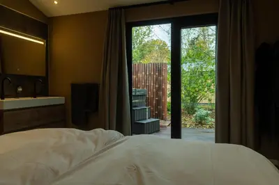a bedroom with a bed and a sliding glass door at Rijn Residentie in Alphen aan den Rijn