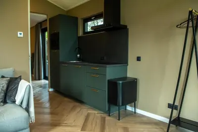 a kitchen with a green cabinet and a television at Rijn Residentie in Alphen aan den Rijn