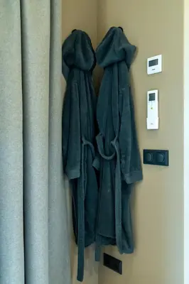two coats hanging on a wall next to a curtain at Rijn Residentie in Alphen aan den Rijn