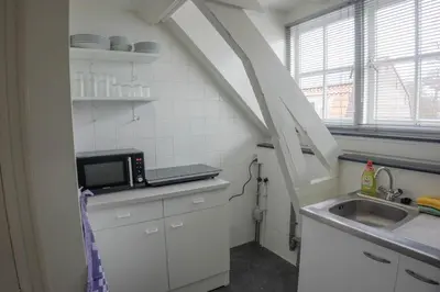 a small kitchen with a sink and a microwave at The Guesthouse in Gouda