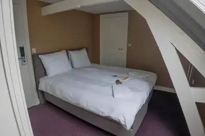 a bed in a small room with an attic at The Guesthouse in Gouda