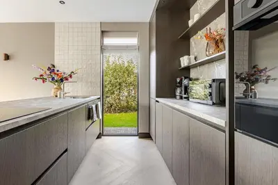 a kitchen with a sink and a counter with a window at Villa Liferla - Wellness met sauna en jacuzzi in Zeewolde