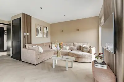 a living room with a couch and a table at Villa Liferla - Wellness met sauna en jacuzzi in Zeewolde