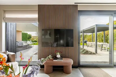 a living room with a large sliding glass door at Villa Liferla - Wellness met sauna en jacuzzi in Zeewolde