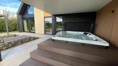 a large bath tub in the middle of a house at Villa Liferla - Wellness met sauna en jacuzzi in Zeewolde