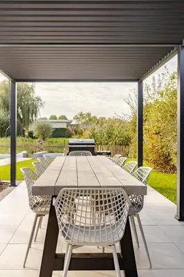 a table and chairs on a patio at Villa Liferla - Wellness met sauna en jacuzzi in Zeewolde