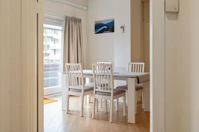 a dining room with a table and chairs and a window at Seebrise Apartment with parking in Zandvoort