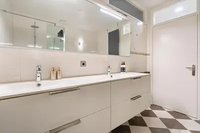 a bathroom with two sinks and a mirror at Seebrise Apartment with parking in Zandvoort