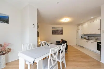 a kitchen and dining room with a white table and chairs at Seebrise Apartment with parking in Zandvoort
