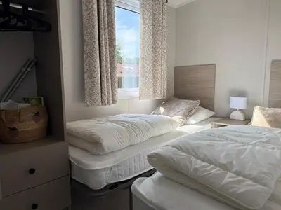 a bedroom with two beds and a window at TETchalet met wellness tuin in Berkhout