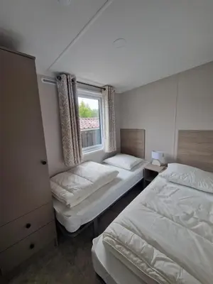a bedroom with two beds and a window at TETchalet met wellness tuin in Berkhout