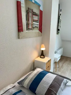 a bedroom with a bed and a lamp on a night stand at Vakantiehuis Castor 300 m van het strand in Noordwijk aan Zee