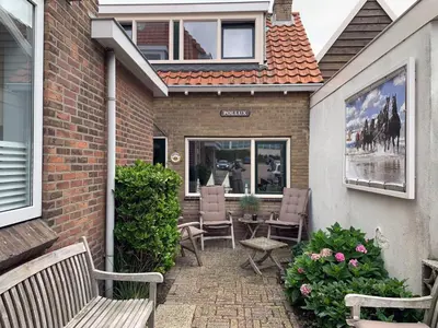 a patio with two benches and a table and chairs at Vakantiehuis Castor 300 m van het strand in Noordwijk aan Zee