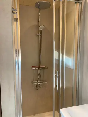 a shower with a glass door in a bathroom at Tiny House The Wave in Noordwijk aan Zee