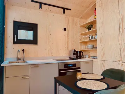 a kitchen with a sink and a table with chairs at Tiny House The Wave in Noordwijk aan Zee