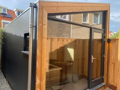 a large sliding glass door on a house at Tiny House The Wave in Noordwijk aan Zee