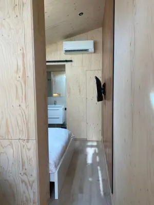 a small bedroom with a bed in a room at Tiny House The Wave in Noordwijk aan Zee