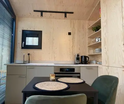 a small kitchen with a table and a sink at Tiny House The Wave in Noordwijk aan Zee