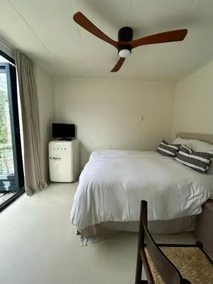 a bedroom with a bed with a ceiling fan at The Surf House Noordwijk in Noordwijk aan Zee