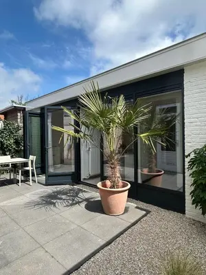 a house with a potted plant on a patio at The Surf House Noordwijk in Noordwijk aan Zee