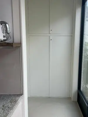 a row of white cabinets in a kitchen at The Surf House Noordwijk in Noordwijk aan Zee