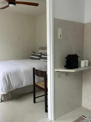 a bedroom with a bed and a chair on a shelf at The Surf House Noordwijk in Noordwijk aan Zee