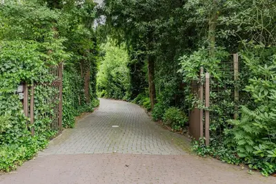 a brick path through a forest with a fence at Villa Nolan in Bergen