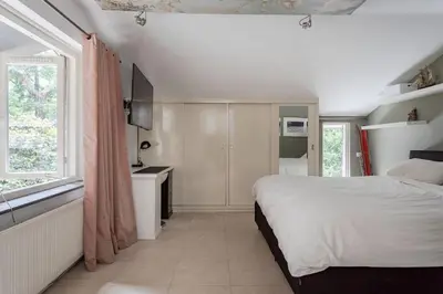 a white bedroom with a bed and a window at Villa Nolan in Bergen