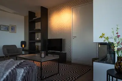 a room with a bed and a table and a tv at Droomsuites Egmond aan Zee 4 personen by Droomvilla in Egmond aan Zee