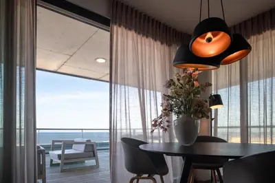 a dining room with a table and a large window at Droomsuites Egmond aan Zee 4 personen by Droomvilla in Egmond aan Zee