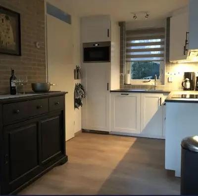 a kitchen with white cabinets and a sink at De Wielen 23 in Sint Maarten