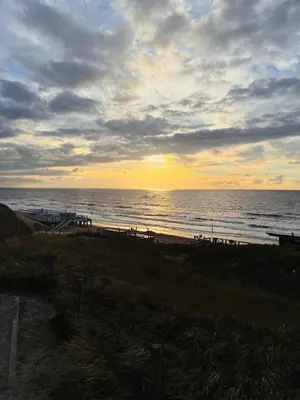 a sunset on a beach with the ocean at De Wielen 23 in Sint Maarten