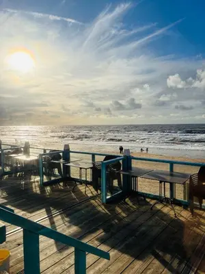 a boardwalk with tables and the ocean on a beach at De Wielen 23 in Sint Maarten