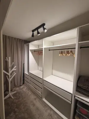 a walk in closet with white cabinets and lights at Kintsugi in Alphen aan den Rijn