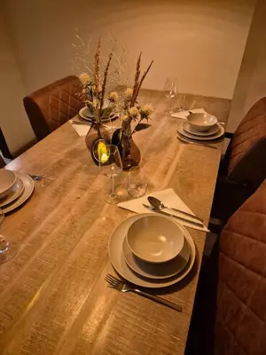 a wooden table with plates and silverware on it at Kintsugi in Alphen aan den Rijn