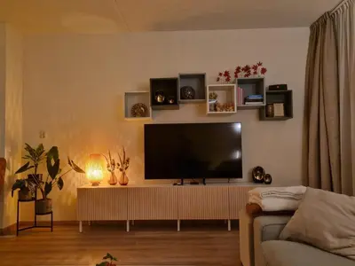 a living room with a flat screen tv on a wall at Kintsugi in Alphen aan den Rijn
