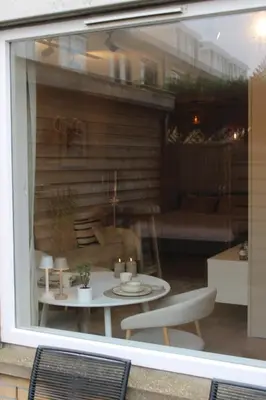 a window view of a table and a couch at Maison Côte - Moderne Studio met Privé Tuin, Nabij Strand & Circuit in Zandvoort