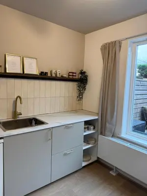 a kitchen with a sink and a window at Maison Côte - Moderne Studio met Privé Tuin, Nabij Strand & Circuit in Zandvoort