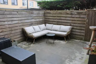 a couch and a table on a patio at Maison Côte - Moderne Studio met Privé Tuin, Nabij Strand & Circuit in Zandvoort