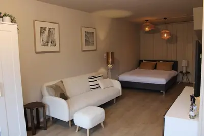 a living room with a couch and a bed at Maison Côte - Moderne Studio met Privé Tuin, Nabij Strand & Circuit in Zandvoort