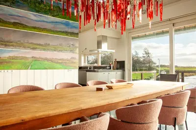 a large dining room with a wooden table and chairs at 10P 4B Luxe Villa with Pool and Sauna in Spijkerboor in Spijkerboor