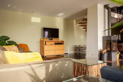 a living room with a couch and a tv at 10P 4B Luxe Villa with Pool and Sauna in Spijkerboor in Spijkerboor