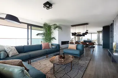 a living room with blue couches and a table at Droomsuites Egmond aan Zee 8 personen by Droomvilla in Egmond aan Zee