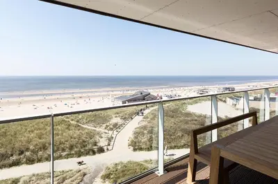 a view of the beach from the balcony of a condo at Droomsuites Egmond aan Zee 8 personen by Droomvilla in Egmond aan Zee
