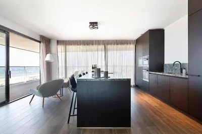 a kitchen with a black island in a room at Droomsuites Egmond aan Zee 8 personen by Droomvilla in Egmond aan Zee