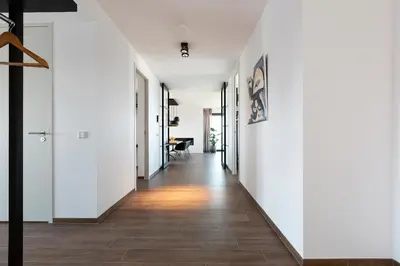 a hallway with white walls and wood flooring at Droomsuites Egmond aan Zee 8 personen by Droomvilla in Egmond aan Zee