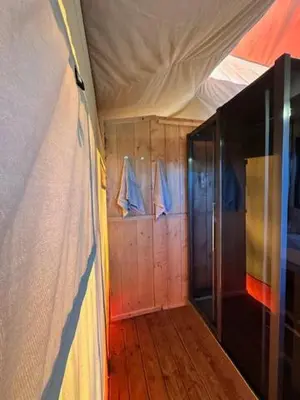 a room with a tent and a wooden floor at Safari Lodge at Back to Basic in Zwaanshoek